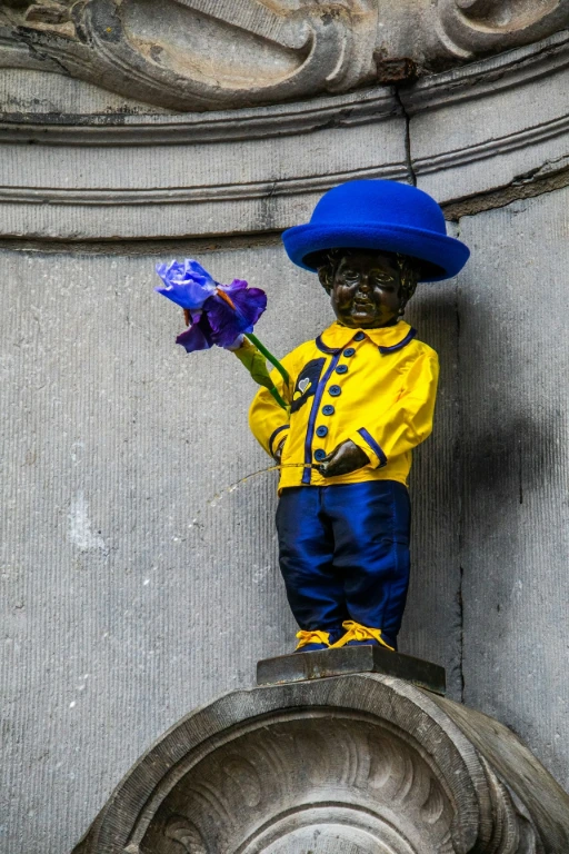 The manneken pis statue wearing a colorful outfit